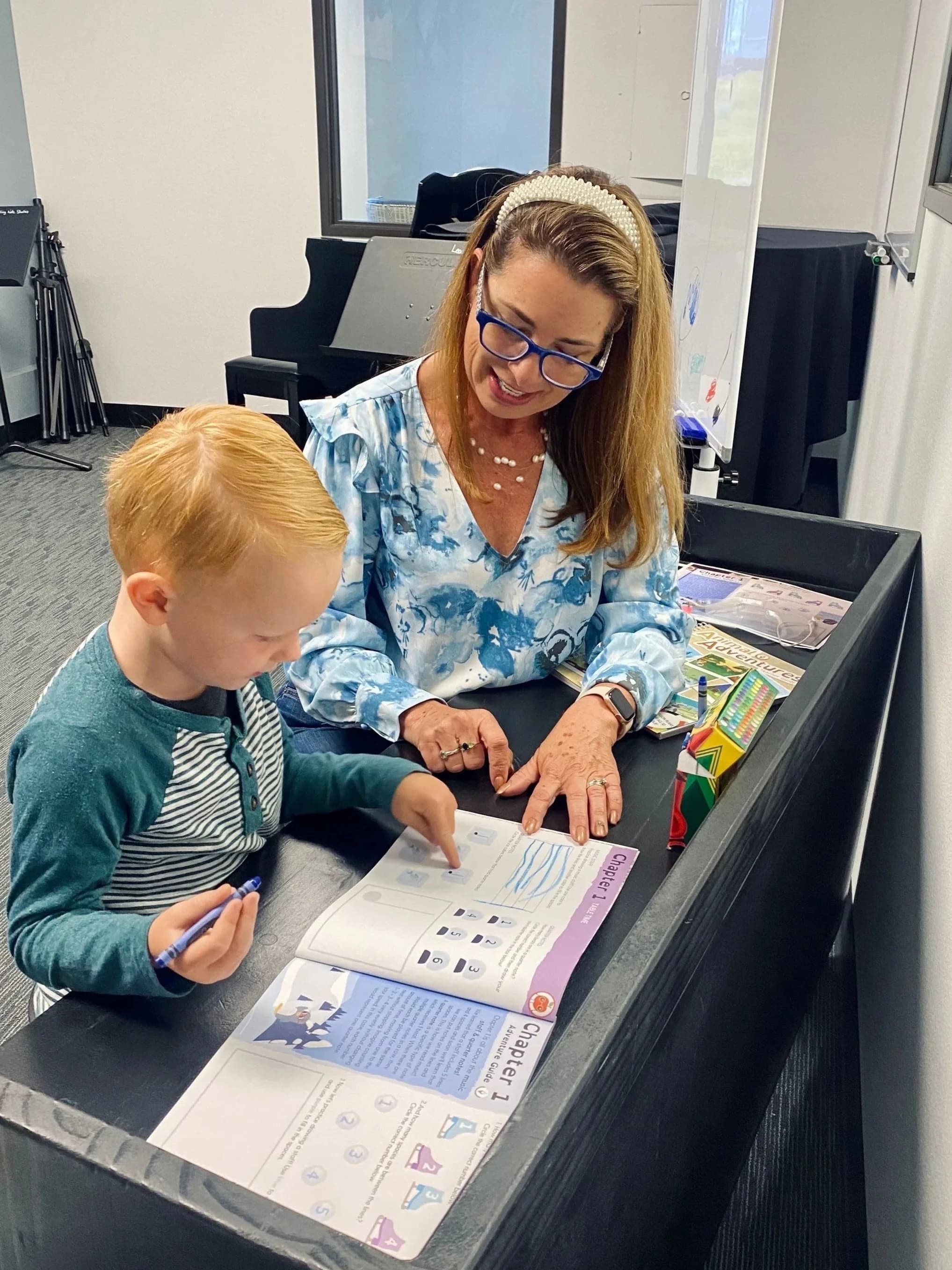 Ms. Agnes guiding a young student through a music lesson
